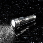 Lumintop GT Nano V3.0 titanium IPX8 waterproof EDC flashlight beam on wet surface water droplets dark background side switch diamond knurling thrower