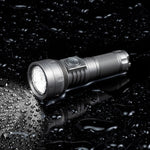 Lumintop GT Nano V3.0 titanium IPX8 waterproof EDC flashlight lying on wet surface water droplets reflection dark background side switch diamond knurling thrower